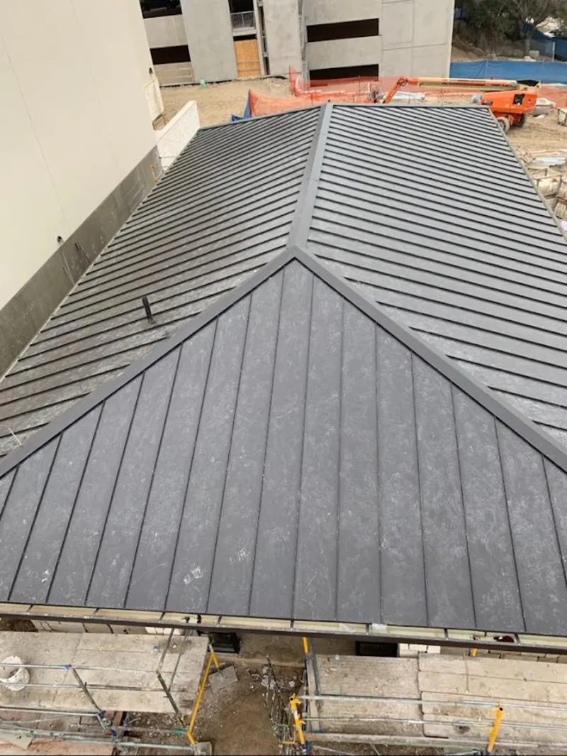Commercial metal roof construction with crane equipment in Crofton